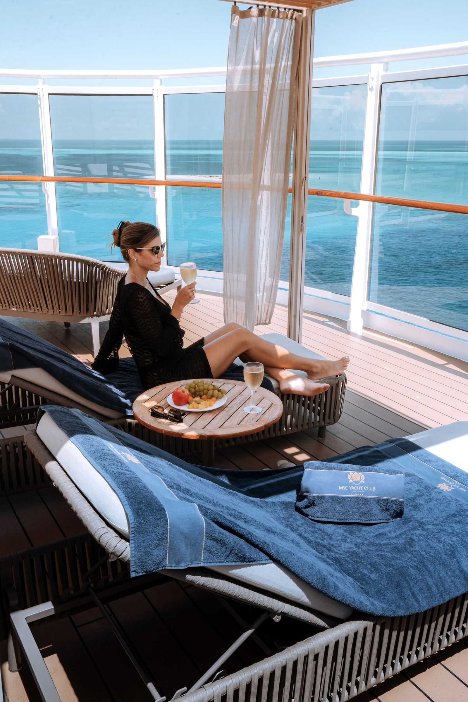 Гостья MSC Yacht Club на солнечной палубе с фирменным полотенцем
