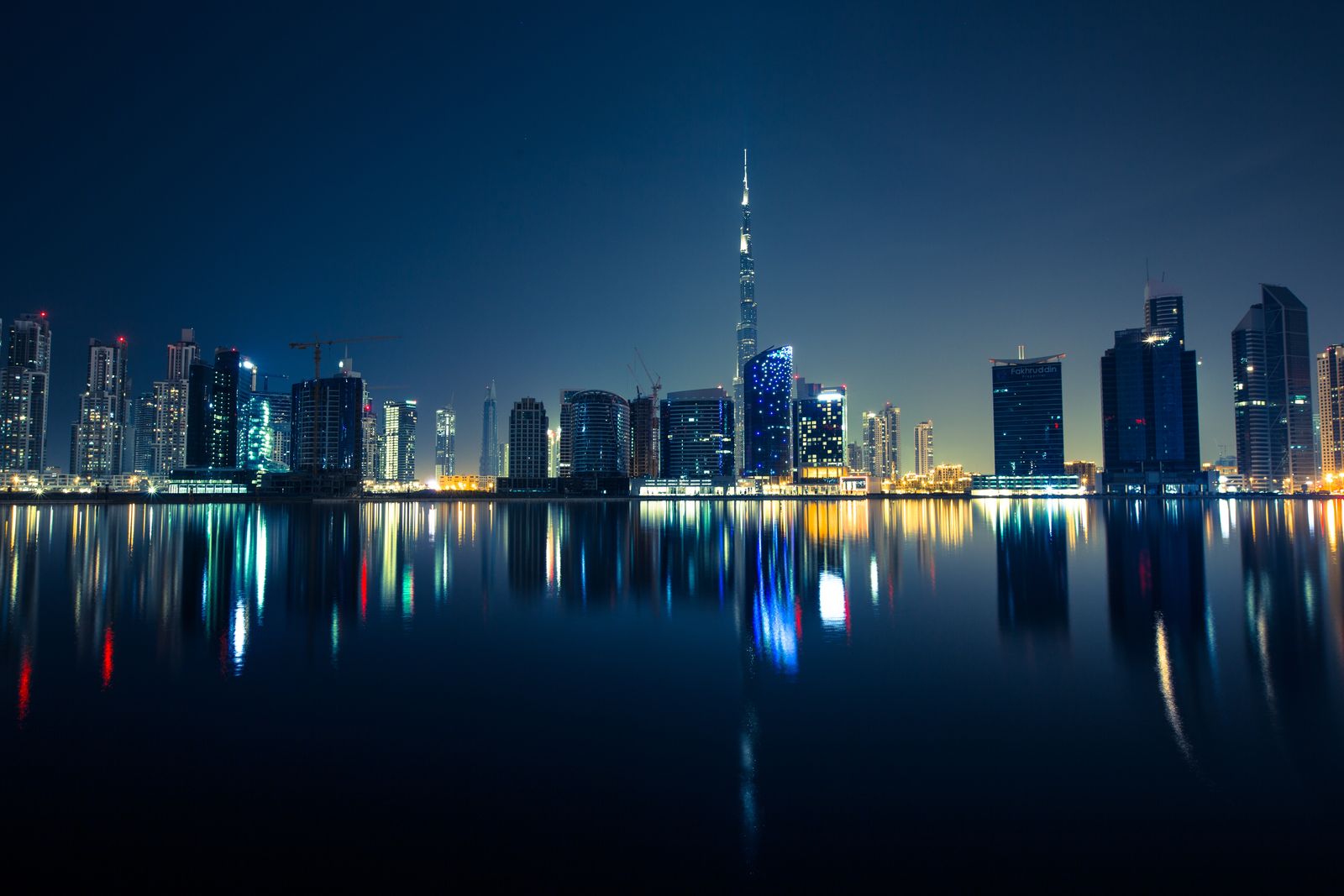 Дубай ночью: небоскрёбы делового центра в отражении воды